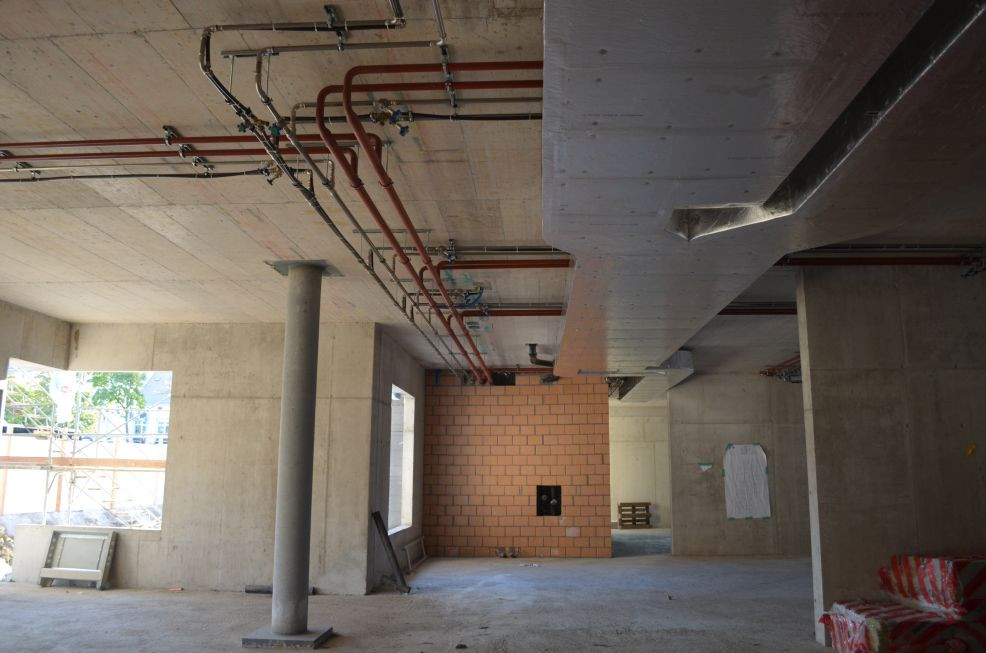 Heizleitungen an der Decke einer Neubauhalle im Rohbau